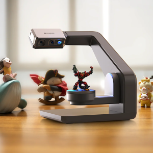A 3DMakerPro Seal 3D Scanner is shown scanning a small figurine atop a rotating platform.